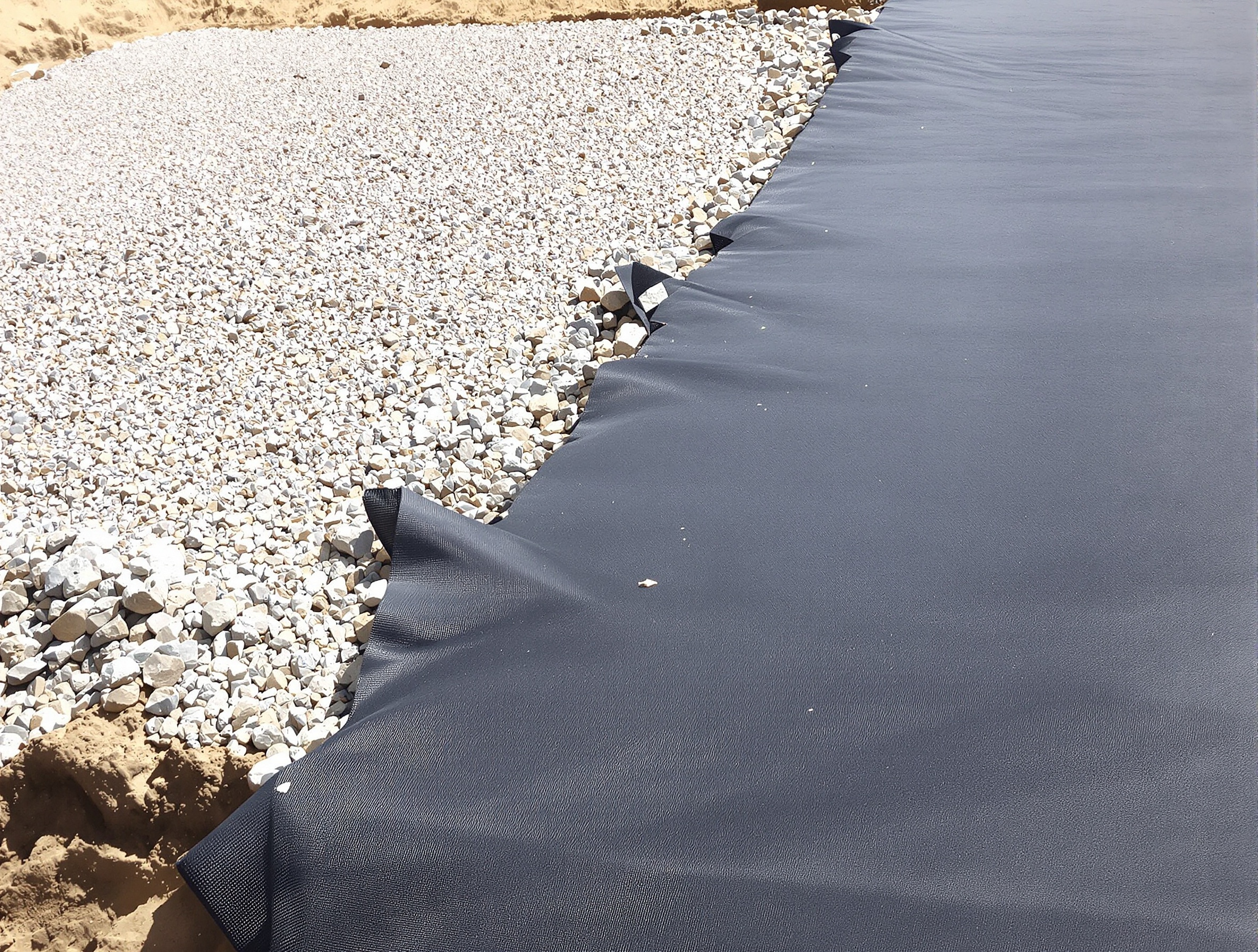 Préparation soignée du sol pour terrasse sur plots : décaissement, géotextile tendu, gravier compacté.