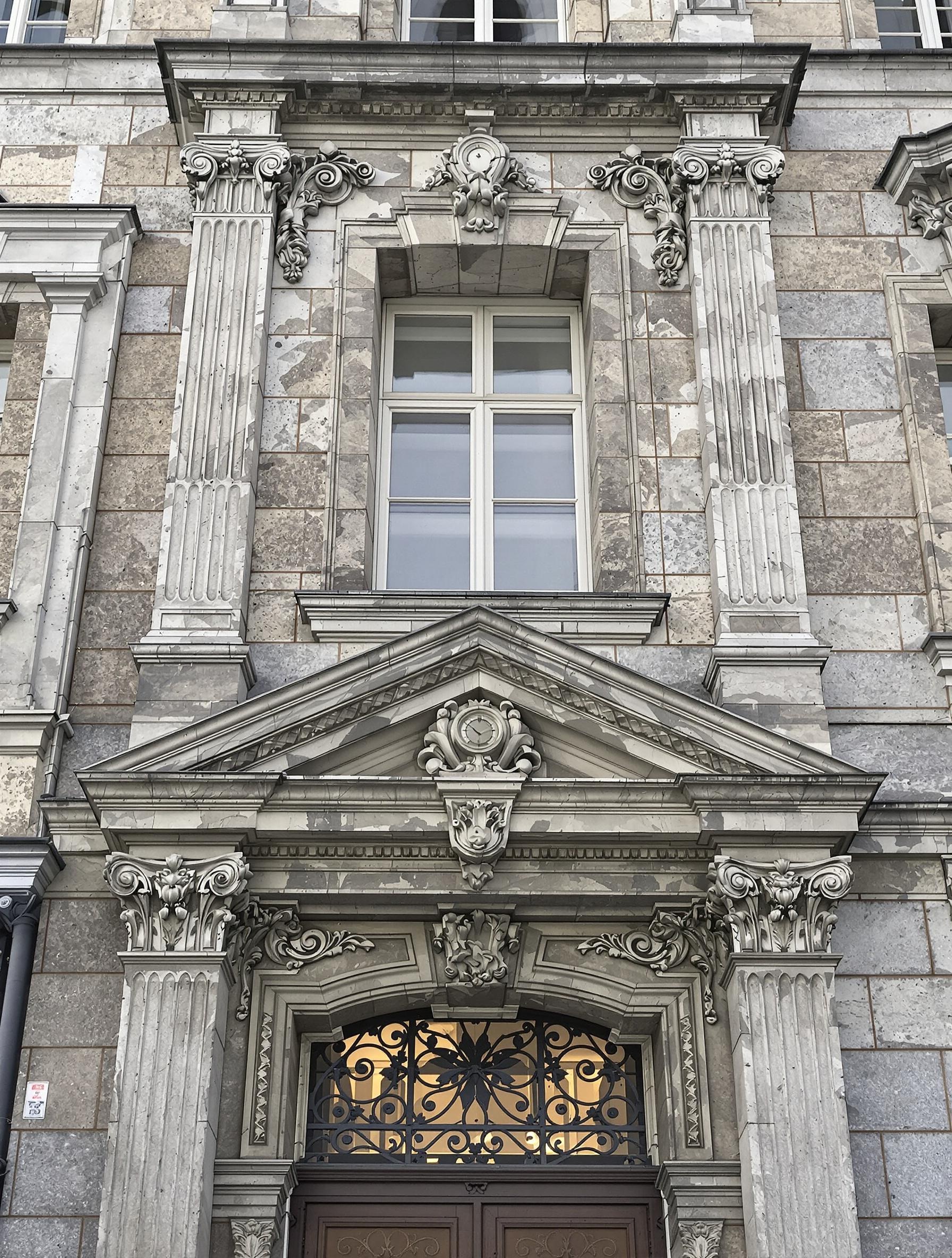Façade classique ornée de modénatures moulures et corniches en pierre naturelle sous ciel breton