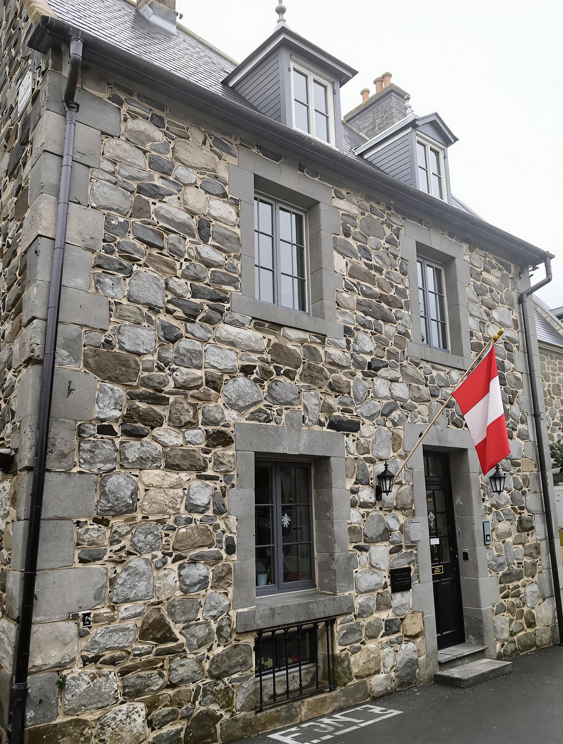 Façade maison bretonne restaurée saine ciel d’embruns drapeau breton paisible surveillance fissures