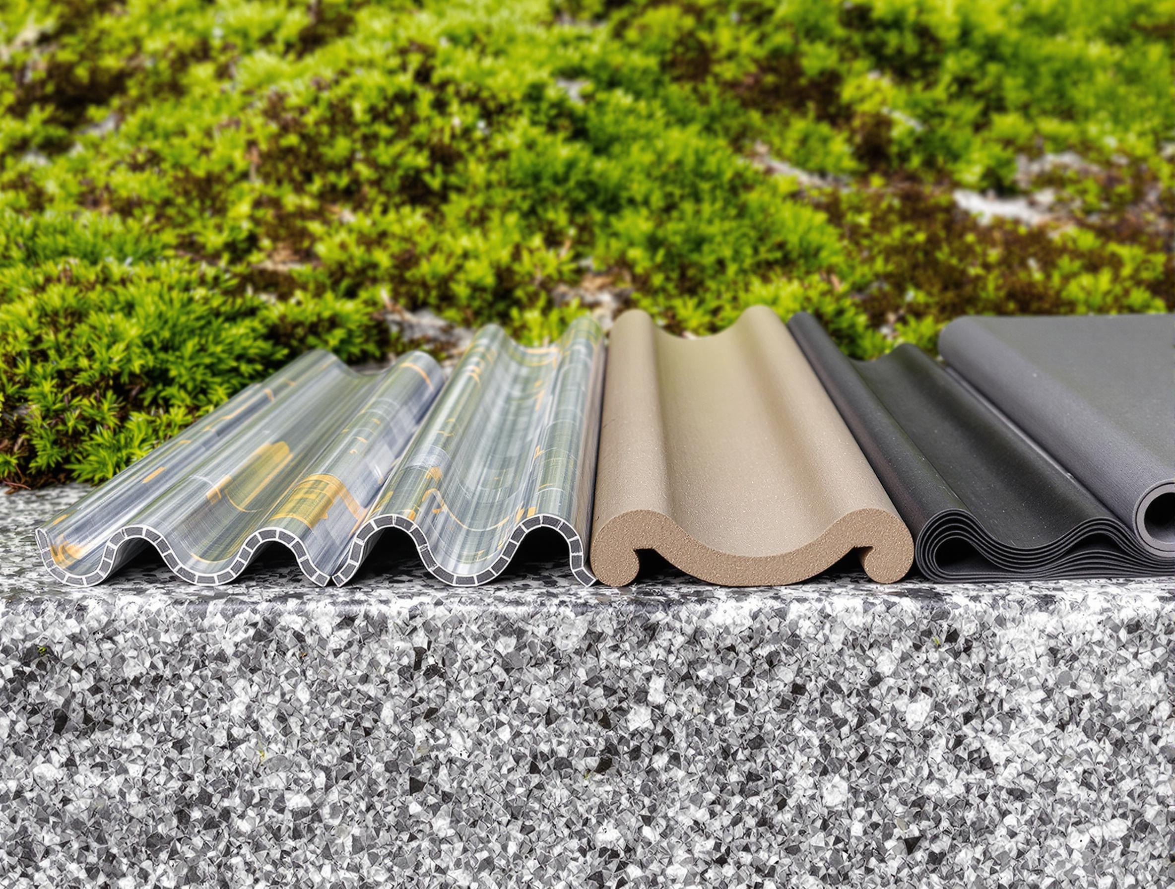 Échantillons de zinc, bac acier, tuile canal et EPDM posés sur granit breton.