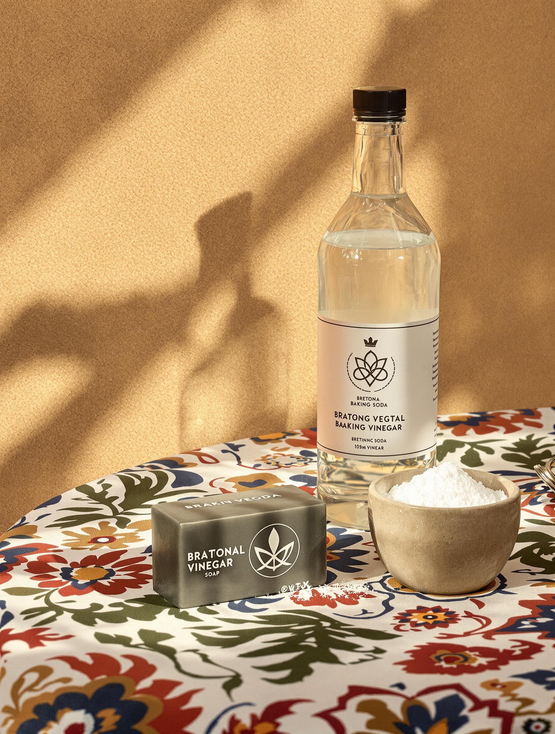 Savon noir breton traditionnel avec vinaigre blanc triskell et pot de bicarbonate sur fond argilo-sableux
